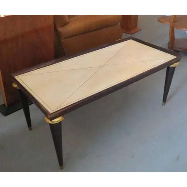 This French Art Deco coffee table is from Maison Jansen. The 1940s table is constructed of stained oak with gold leaf...