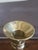 Neoclassical Corinthian polished brass column candlestick holder featuring a fluted stem and a square, tiered base.