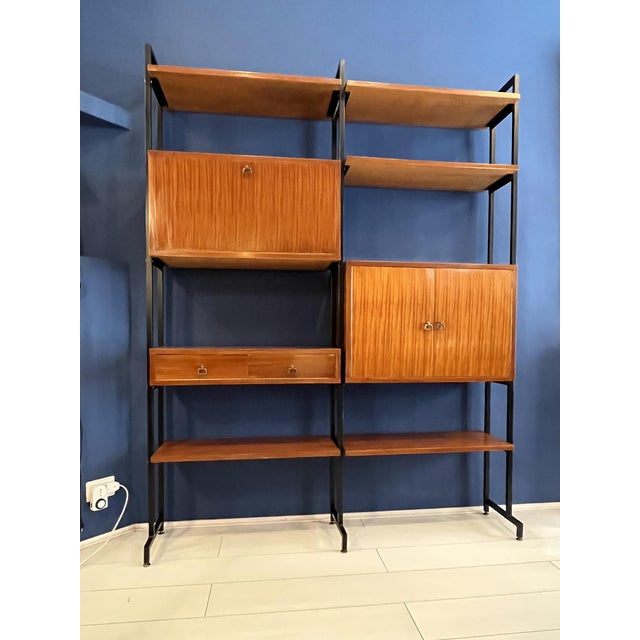 Restored modular wooden bookcase with black painted iron uprights. It includes shelves and two closed compartments, one...