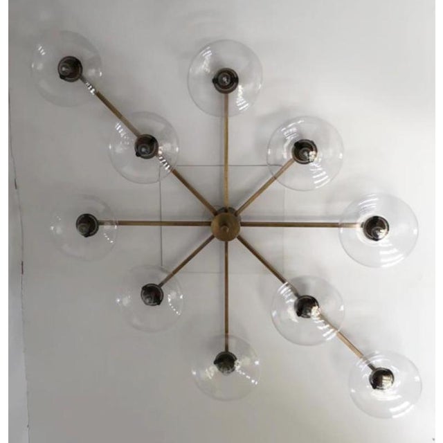 Italian midcentury flush mount with ten clear Murano glass shades mounted on solid brass frame in bronze finish / Made in...
