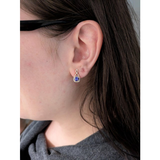 Rare and radiant, these earrings feature 1.55 carats of cushion-cut Tanzanite—known for its unique blue-violet glow—set in...