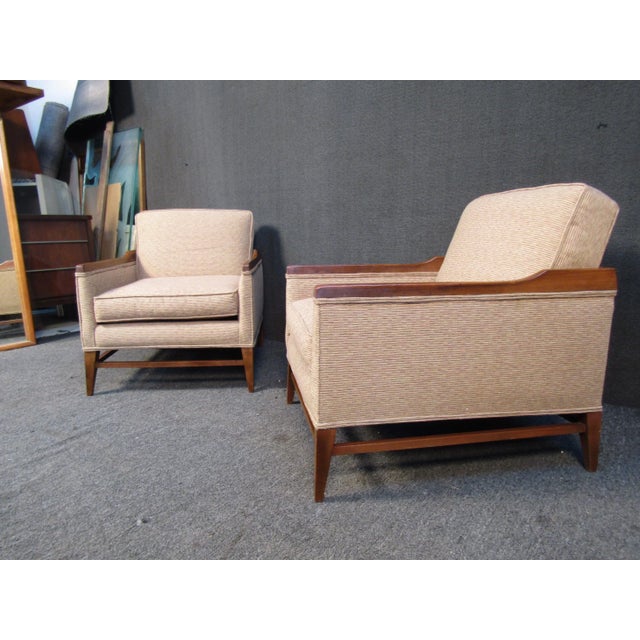 Pairing a warm beige upholstery with walnut frames, this vintage pair of lounge chairs are a versatile way to add Mid-...
