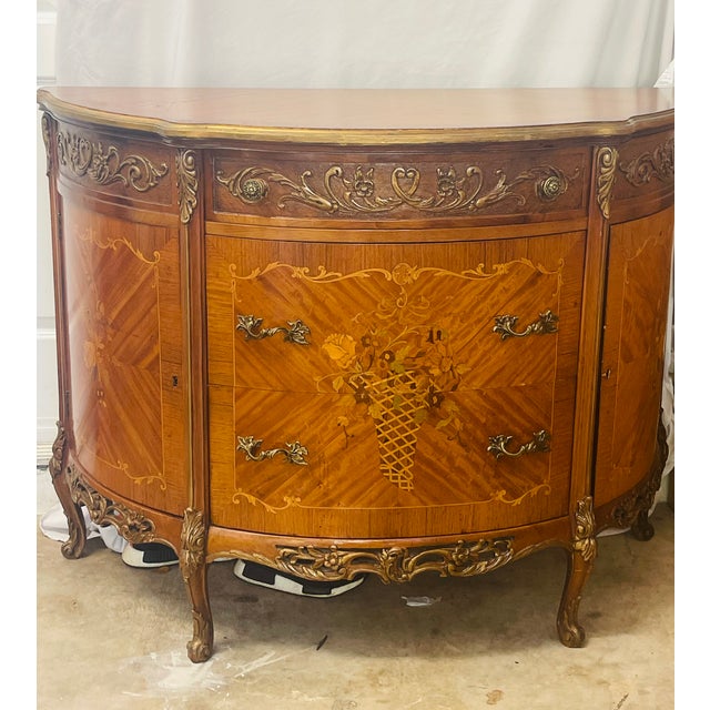 Early 20 th c French Demilune commode in Louis XVi style with fruit wood inlay and bronze hardware decor. Two drawers and...
