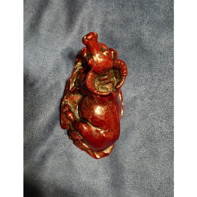 This is a Chinese zodiac ox figurine crafted from red resin with gilded detailing, commonly used as a Feng Shui desktop or...
