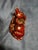 This is a Chinese zodiac ox figurine crafted from red resin with gilded detailing, commonly used as a Feng Shui desktop or...