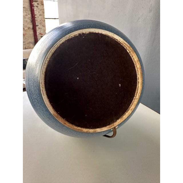 This table lamp is skillfully crafted by Design Technics, boasting a unique teardrop shape and a stunning glaze of blues...