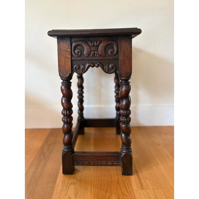 Antique solid oak side table made and stamped Belgium features four barley twist legs and hand carved motifs on both the...