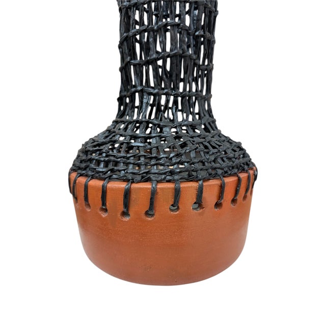 This sculptural vase is a bold celebration of contrast and craftsmanship. Hand-thrown in Brazil, the warm terracotta base...