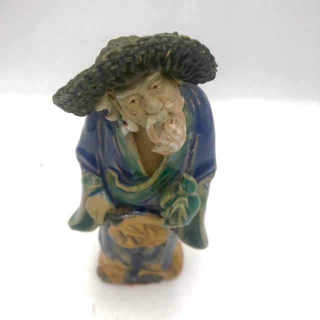 Antique Chinese mudman holding bad of coins and fan. Made in the Late 19th Century
