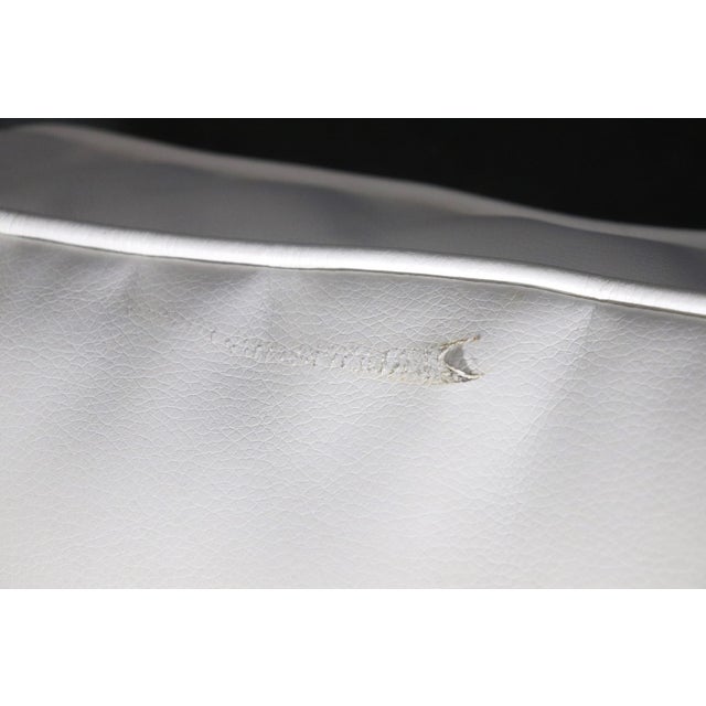 Large club chairs with polished brass base and cut out arms.