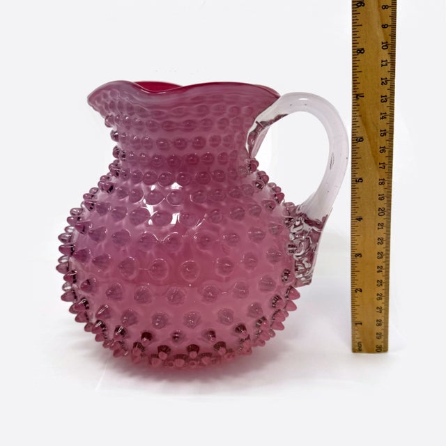 This is a stunning example of Victorian-era art glass: an authentic Hobbs, Brockunier & Co. cranberry glass pitcher in the...