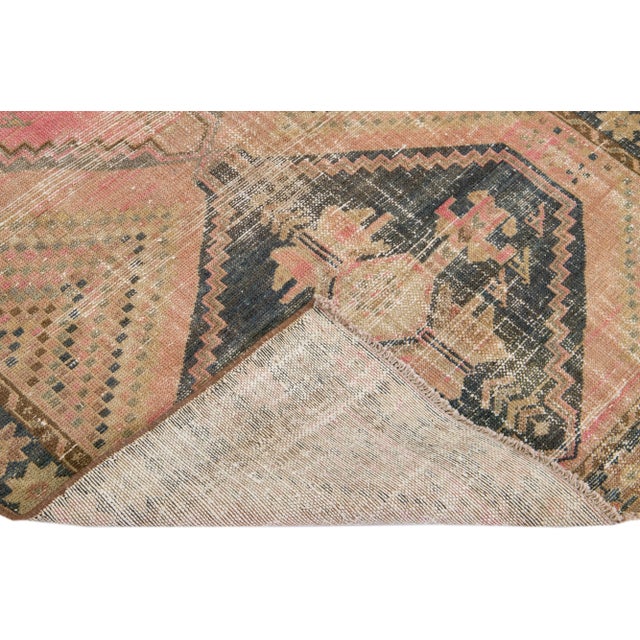 Beautiful Vintage Distressed hand-knotted wool rug with a peach field. This Persian rug has blue frame and multicolor...