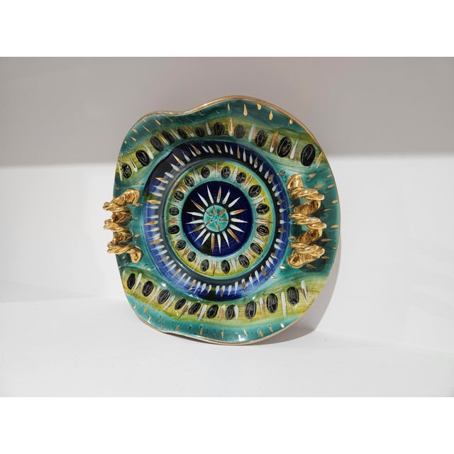 Quaregnon ceramic plate by H. Bequet. Rich shades of blue, green, yellow and gold, hand-painted ceramic plate, produced in...