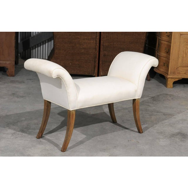 An English Mid-Century Modern small size bench with out-scrolled arms and saber legs. This English bench from the 1950s...