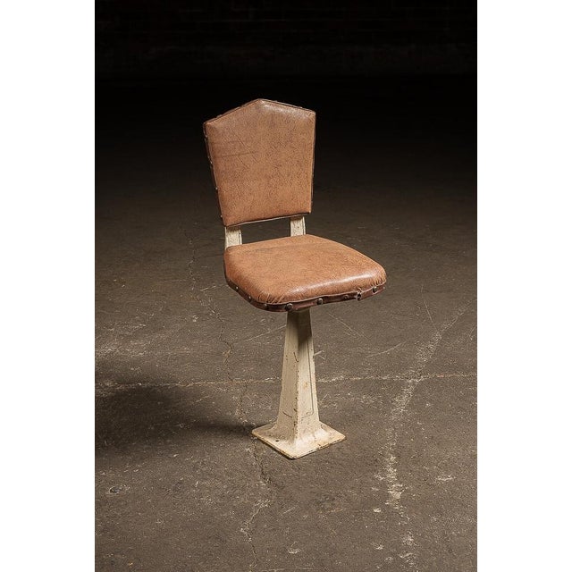 Cast iron and steel pedestal chair with a tapered, flared porcelain base, retaining its brown upholstered seat and back...