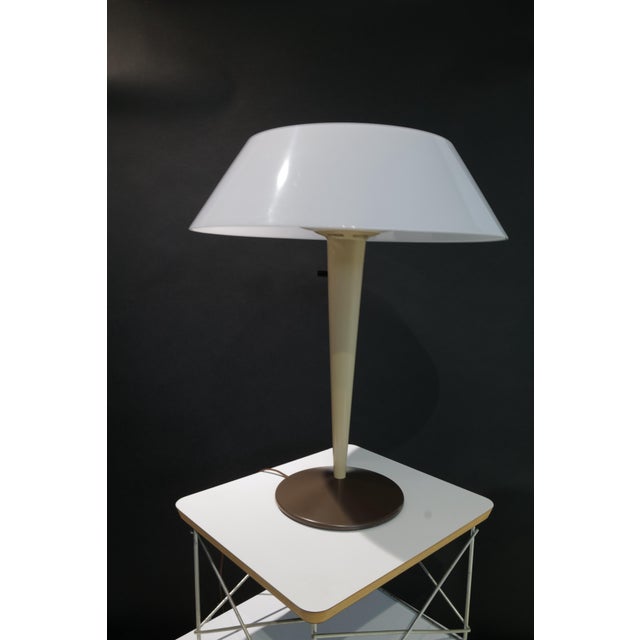A striking mid-century modern table lamp designed by Gerald Thurston for Lightolier, featuring its original molded white...