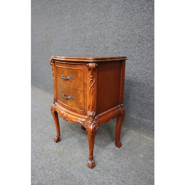 Mahogany two drawer nightstand with carved detailing and shaped front. Features carved corner accents, decorative apron,...