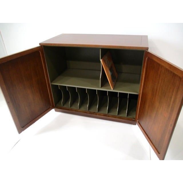 A well crafted walnut toned mahogany two door stereo record cabinet with brass pulls , lower record area for 45's and 78's...