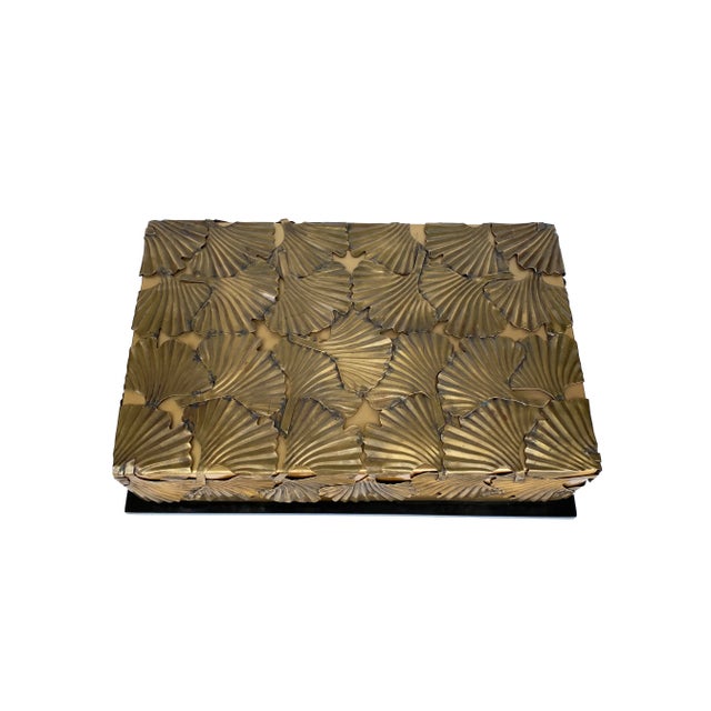 A glamorous Art-Deco style accessory box with aged-brass etched and sculptured ginkgo leaf pattern on a sleek glossy black...