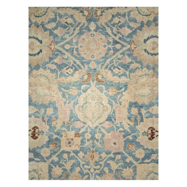 This early 20th-century Persian Tabriz carpet presents a refined allover floral composition across a soft blue field,...