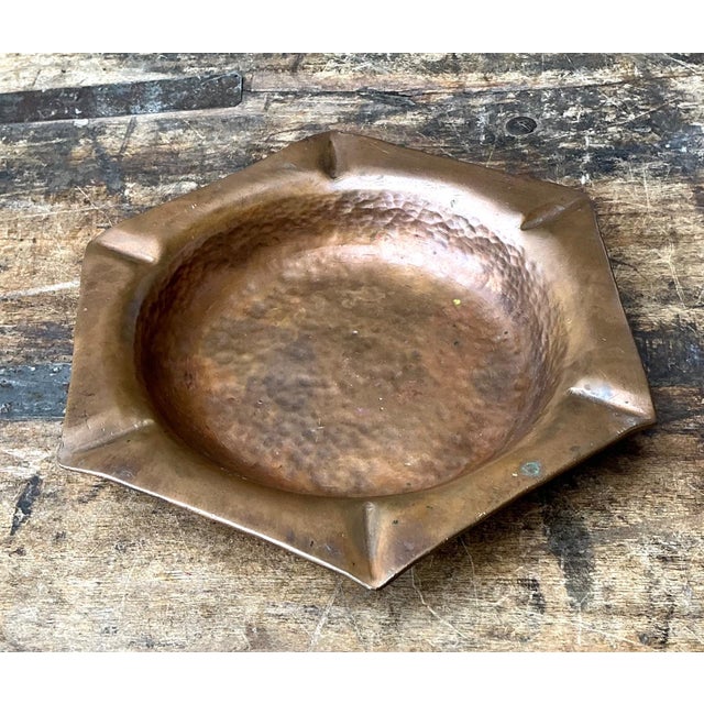 This vintage hexagonal ashtray is a compelling example of handcrafted metalwork, showcasing the enduring beauty of...