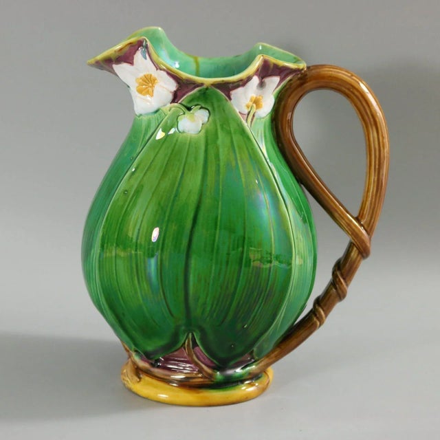 Minton Majolica jug/pitcher which features flowering lilies and lily pads. Colouration: green, white, dark pink, are...