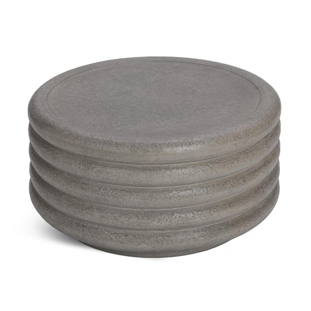 Sculptural outdoor coffee table crafted from lightweight concrete with stacked banding and substantial low-profile...