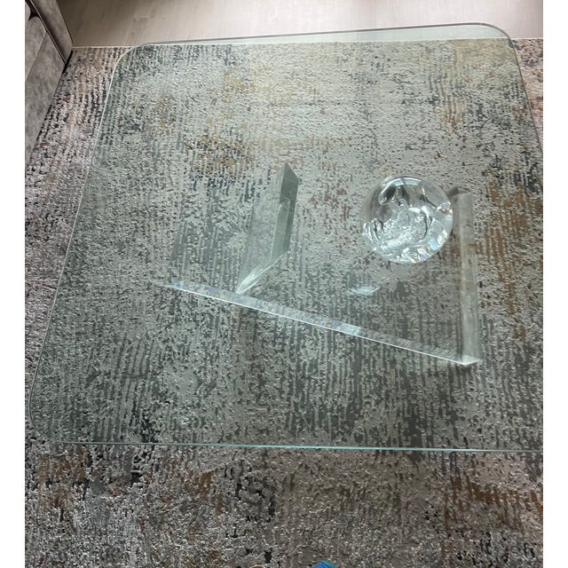 1970's designer coffee table with a thick rounded corner square glass top and a geometric, sculptural lucite acrylic base....