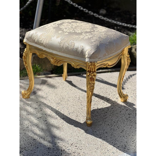 Hand Carved Banquet stool ottoman made From real solid wood gilded by real gold leaf. Width 22”, depth 15” and Height of 18”