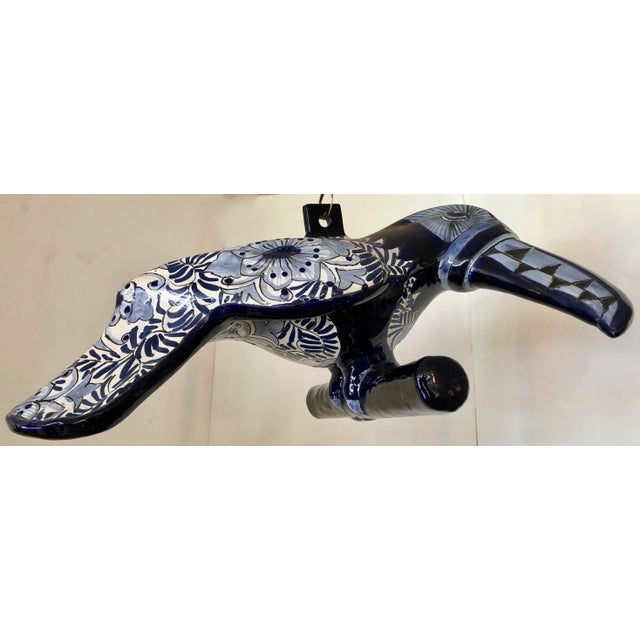 This is gorgeous ceramic toucan on a perch made and hand painted in Mexico. It is in white and different tones of blue....