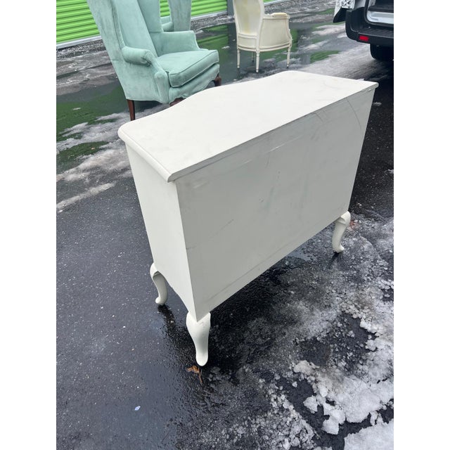 This charming white hand-painted cabinet features graceful serpentine drawer fronts, cabriole legs, and a softly contoured...