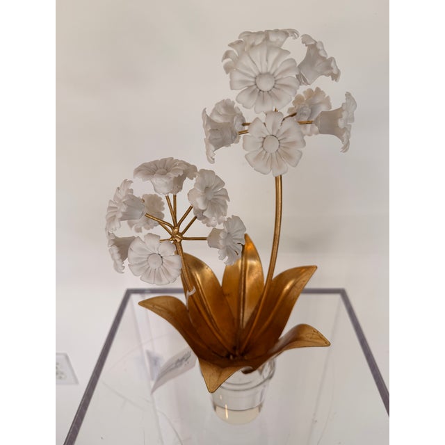 Elegant contemporary floral sculpture featuring delicate porcelain blossoms accented by rich gold leaf metal stems and...