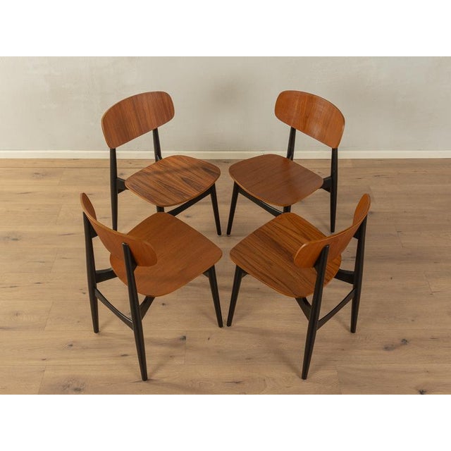 Classic dining chairs from the 1960s. High-quality frame in black lacquered beech wood with seat and back shell made of...