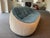 Designer Ligne Roset Ottoman sofa has a unique shape with quilted teal blue upholstery and a light cream base. This high-...