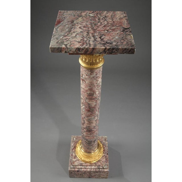 Brocatelle marble display column with sculpted and gilt bronze cap and base. The capital is embellished with ovals and...