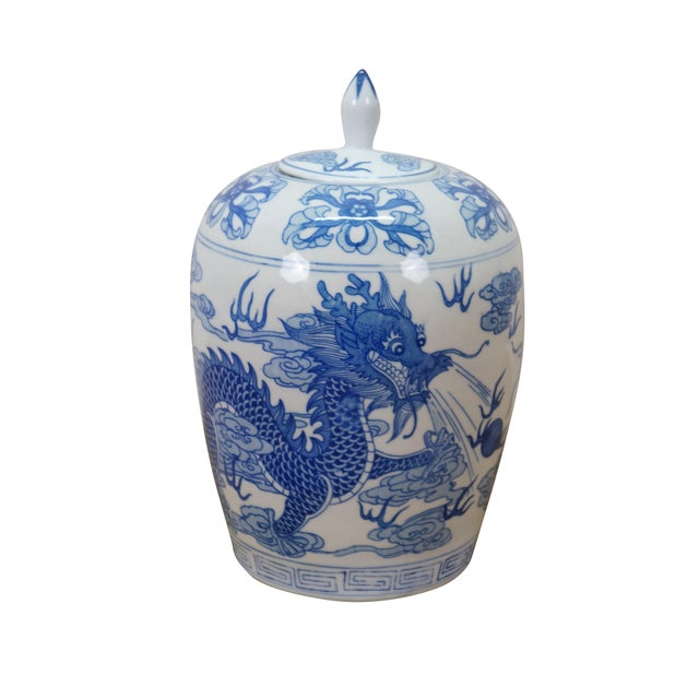 Vintage Chinese porcelain lidded ginger jar vase decorated in a blue and white floral 5 toed dragon in the clouds motif....