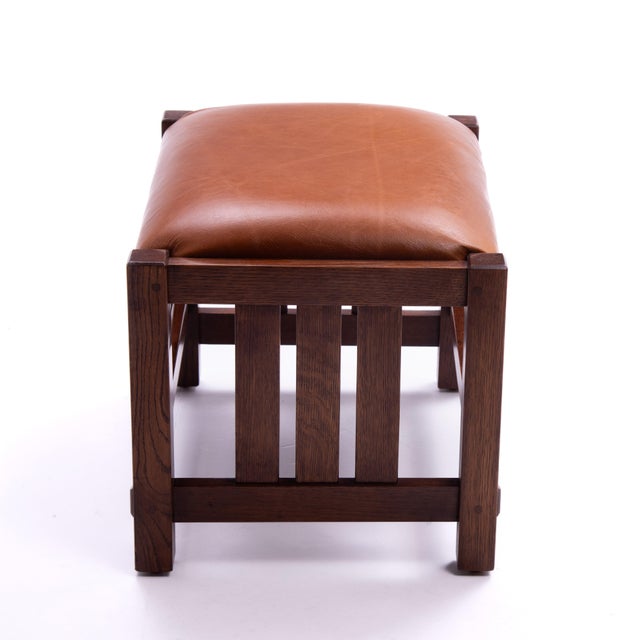 An L&JG Stickley footstool from 2008. Original finish, the footstool has been recovered in a quality caramel colored leather.