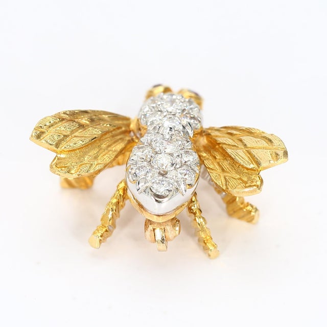 This small bee shaped pin is covered by sixteen diamonds on its back and two rubies for the eyes. Stone Info: 2x Rubies...