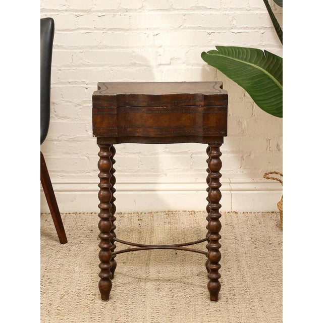 A charming vintage sewing or side table featuring a shaped serpentine case, dark wood finish, and four barley twist legs...