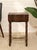 A charming vintage sewing or side table featuring a shaped serpentine case, dark wood finish, and four barley twist legs...