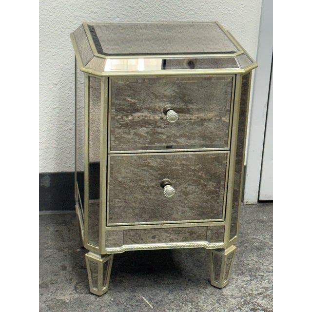 Design Plus Gallery presents the Petite Two-Drawer Mirrored Chest from Stein World. Antiqued mirrored panels cover the...