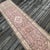 A Vintage Runner with Soft Geometry, Floral Detail, and Pastel Charm This vintage runner rug is hand-knotted approximately...