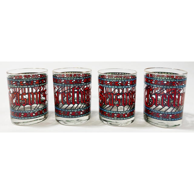 These seventies-era lowball glasses feature a colorful wraparound stained glass design declaring Seasons Greetings....