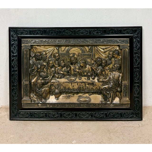 Decorative Spanish wall relief depicting The Last Supper, presented in a richly carved metal frame. The central relief...