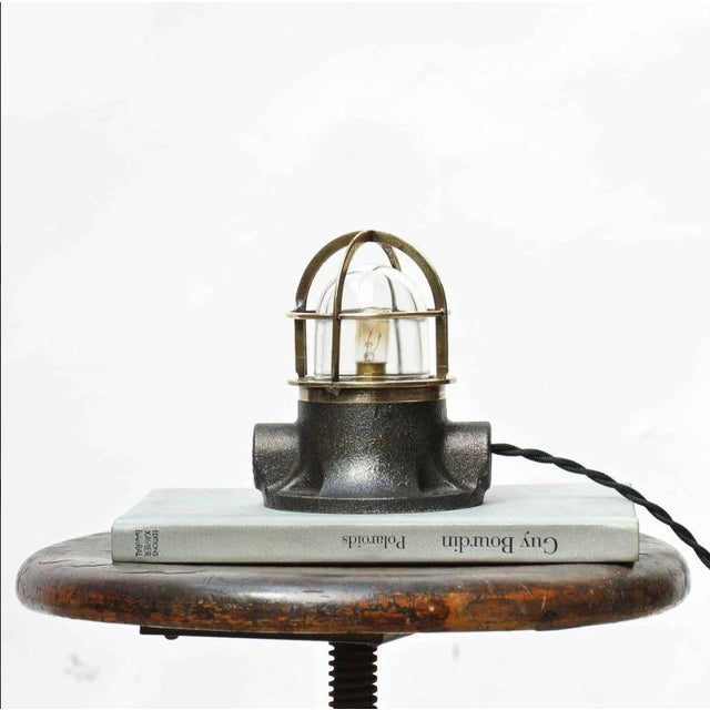 Nice model of an old signal lamp. Patinated and polished cast aluminum base. Fine brass grille protecting the glass. To...