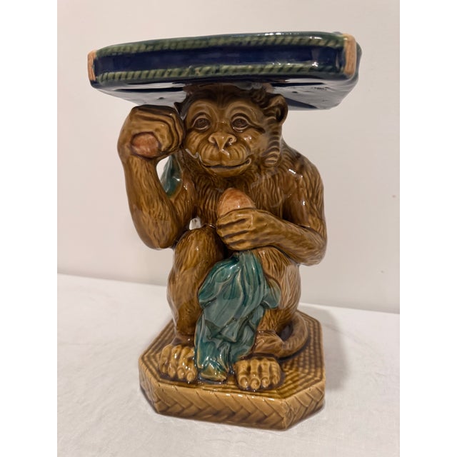 Charming vintage majolica ceramic pedestal featuring a seated monkey holding a fruit and supporting a tray or stand...