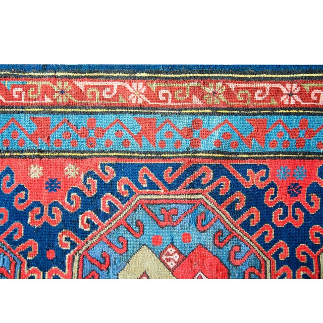 An incredible early 20th century Persian Kazak rug with three central medallions each with an endless knot pattern...