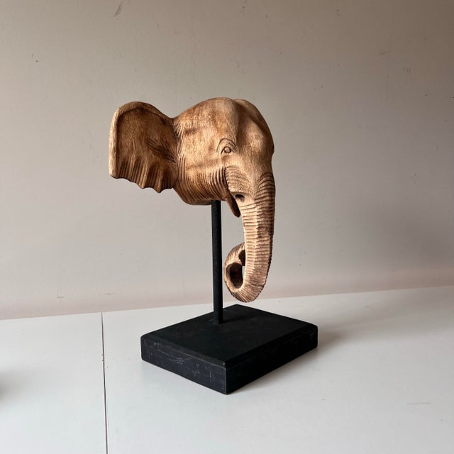 Great wood carved elephant head in a wooden pedestal base. In neutral tones this piece is a bit British Colonial and a bit...