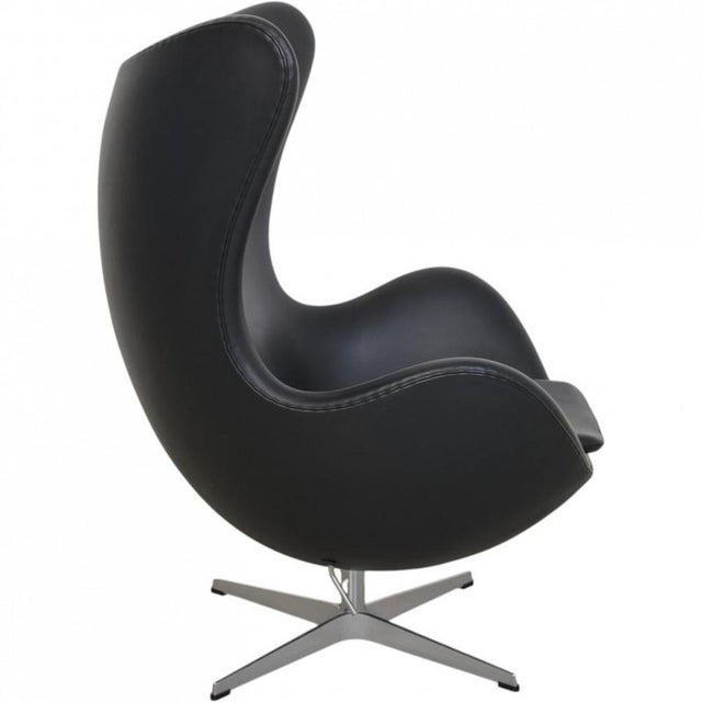 Arne Jacobsen Egg chair upholstered in original black Aura leather, and with a base of brushed aluminium. The chair is...
