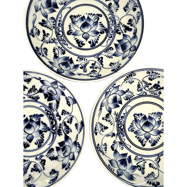 A beautiful set of four Bat Trang dessert plates, featuring a richly detailed blue-and-white lotus floral design inspired...